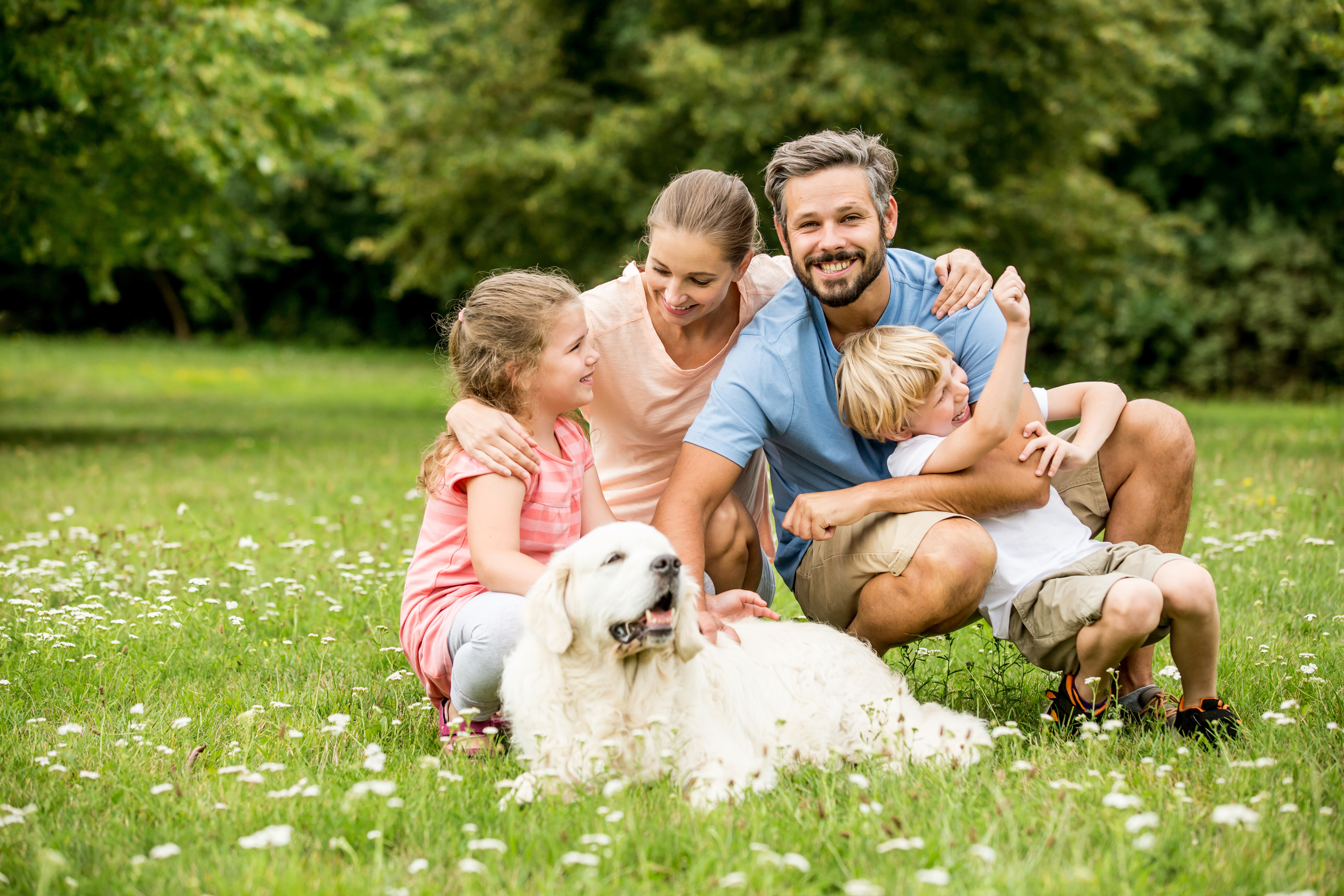 happy dog with his family and kids in the garden.